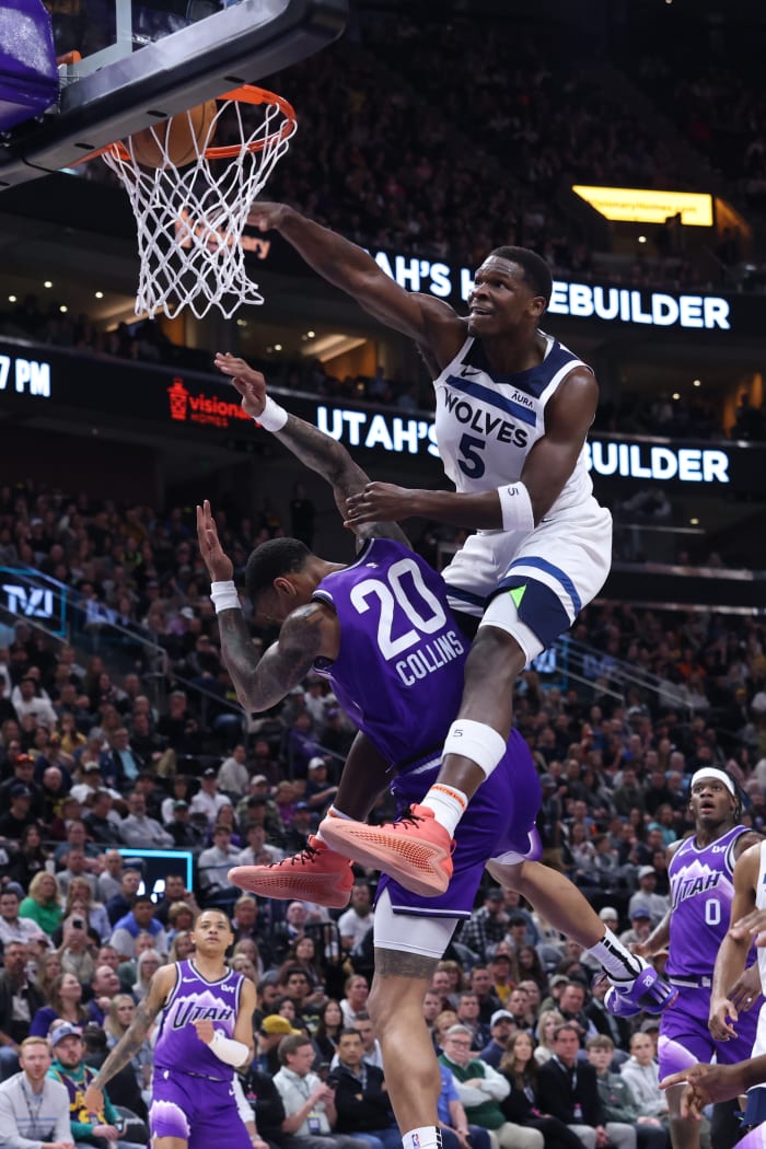 Minnesota Timberwolves guard Anthony Edwards dunks over Utah Jazz forward John Collins.